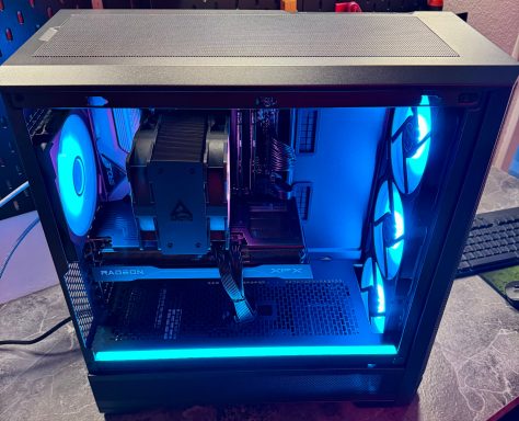 Moderne Gaming-PC mit blauer Beleuchtung und sichtbaren Komponenten.